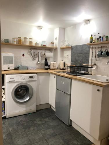 une cuisine avec une machine à laver et un évier dans l'établissement L'Aiguillerie, à Montpellier