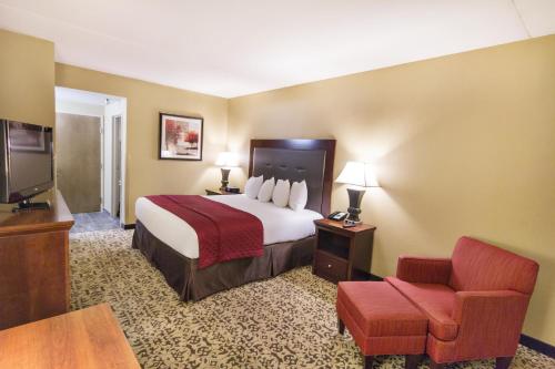 um quarto de hotel com uma cama e uma cadeira em Grand Oaks Hotel em Branson