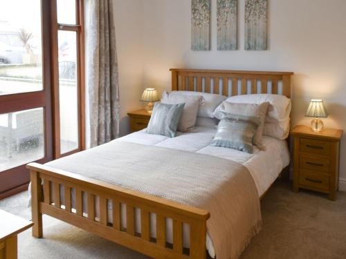 ein Schlafzimmer mit einem großen Bett mit zwei Nachttischen und zwei Lampen in der Unterkunft The Ginnel Mews in Skipton