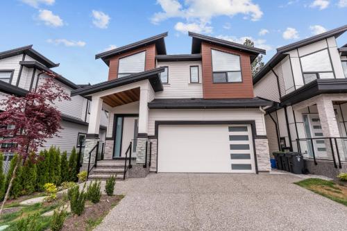 a house with a white garage door at Charming, Cheerful, Exquisite 4 BR house, free wifi, free parking, free cancelation in Langley
