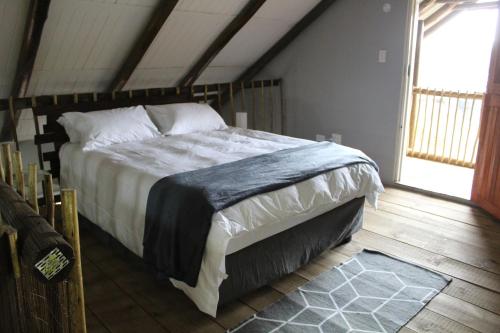 um quarto com uma cama grande num sótão em Self-Catered Apartment With Pool em Krugersdorp