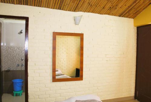 a bathroom with a mirror on a white brick wall at Windsor Cottages in Lansdowne