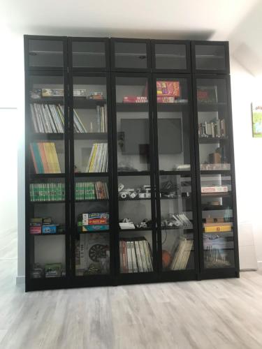 une étagère noire remplie de nombreux livres dans l'établissement Gite de la Mer, à Penmarcʼh