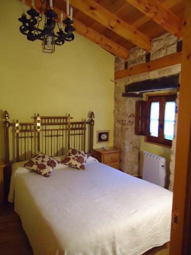 a bedroom with a white bed and a window at El Salto del Agua Auténtico El Molino de la Cascada Orbaneja in Orbaneja del Castillo