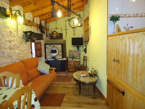 ein Wohnzimmer mit einem Sofa und einem Tisch in der Unterkunft El Salto del Agua Auténtico El Molino de la Cascada Orbaneja in Orbaneja del Castillo