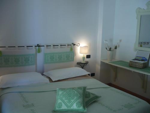 a bedroom with two beds and a lamp and a mirror at Le Pavoncelle in Alghero