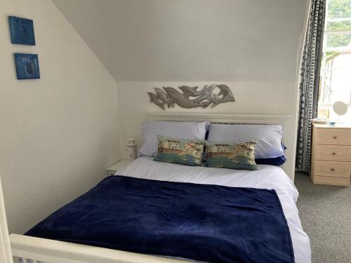 a bedroom with a bed with blue sheets and pillows at Coastal Views Millport in Millport