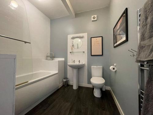 a bathroom with a sink and a toilet and a bath tub at Seafield Lodge in Grantown on Spey