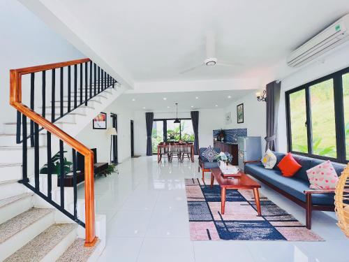 ROSE Villas & Resort - Ba Vi في هانوي: غرفة معيشة مع أريكة زرقاء وطاولة