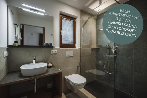 a bathroom with a sink and a toilet and a shower at Apartments Koflhaus in Cadipietra