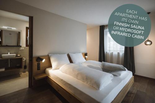 a bedroom with a large white bed with a mirror at Apartments Koflhaus in Cadipietra