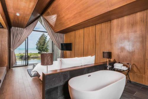 a large bathroom with a tub and a bed at Ana Anan Resort & Villas Pattaya in Na Jomtien