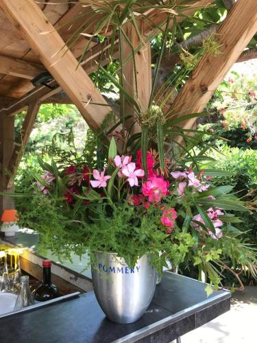 a pot of flowers sitting on top of a table at Hôtel Restaurant Les Chasseurs in Marine de Pietracorbara
