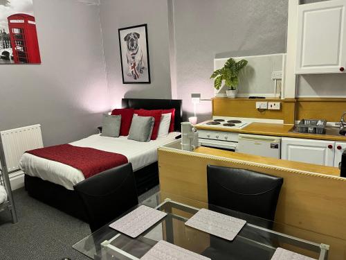 a small room with a bed and a kitchen at On The Beach Apartments in Blackpool