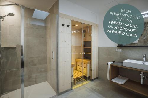 ein Bad mit einer Dusche und einem Waschbecken in der Unterkunft Apartments Koflhaus in Steinhaus
