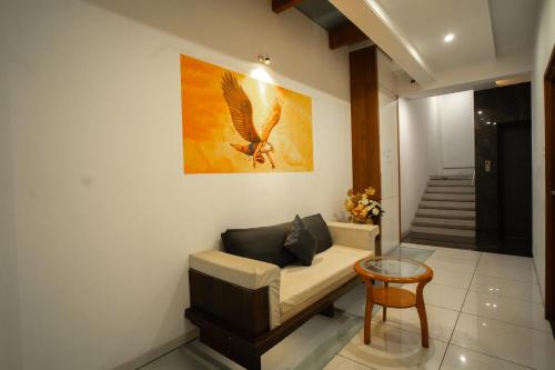 a living room with a couch and a painting on the wall at Hotel SRI SRI EXECUTIVE KOLHAPUR NEAR MAHALAXMI TEMPLE in Kolhapur