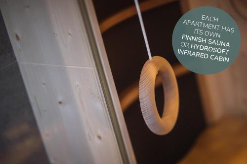 a piece of wood hanging from a door with a sign at Apartments Koflhaus in Cadipietra