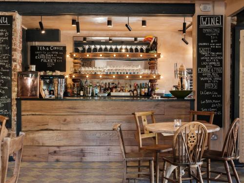 a restaurant with a wooden bar with a table and chairs at Fairlight Cove in Fairlight