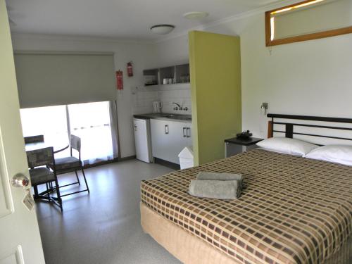 a bedroom with a bed and a kitchen in it at Lakeside Tourist Park in Robe