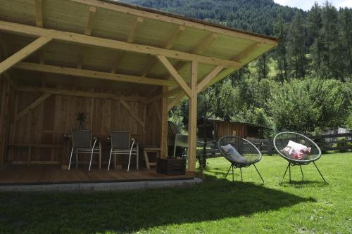 a gazebo with two chairs in a yard at Apartments Koflhaus in Cadipietra