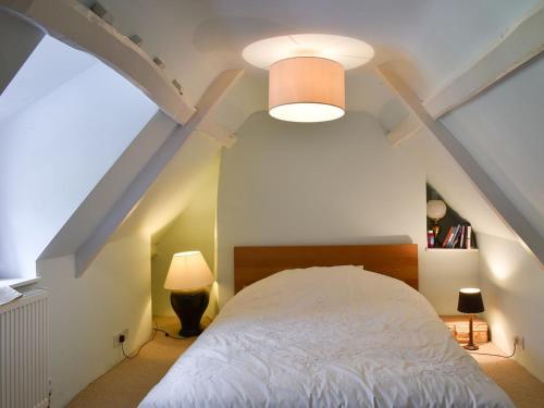 a bedroom with a white bed in a attic at St James Cottage in Shaftesbury