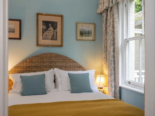 什魯頓的住宿－The Nook At Henge Estate，一间卧室配有一张蓝色墙壁的床和一扇窗户