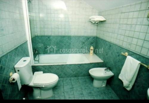 uma casa de banho com um WC, um lavatório e uma banheira em La Rectoral de Valdedios.Casa rural con chimenea 
