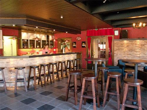 um bar com bancos de madeira num restaurante em Hotelli Haapakannel em Haapavesi