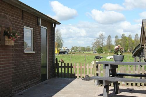 a picnic table next to a brick building with a field at Hofstay195 in Achterveld