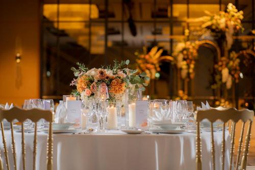 a table with a white table cloth and flowers on it at Melia Chiang Mai in Chiang Mai