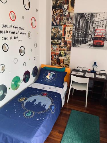 a bedroom with a bed and a desk and posters at B&BMagicHouse in Novara