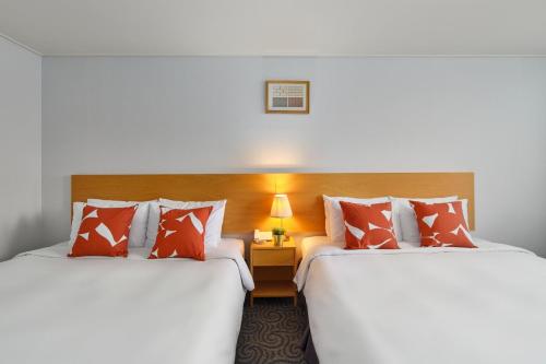 two beds sitting next to each other in a room at Hotel Atrium Jongno in Seoul