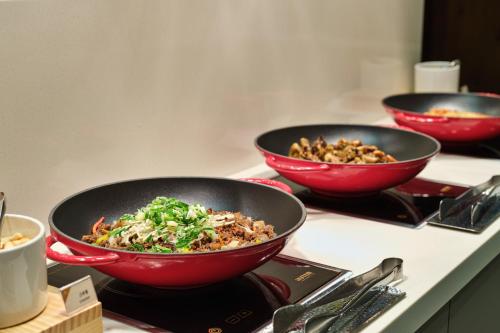 three bowls of food sitting on a counter at Hotel Atrium Jongno in Seoul