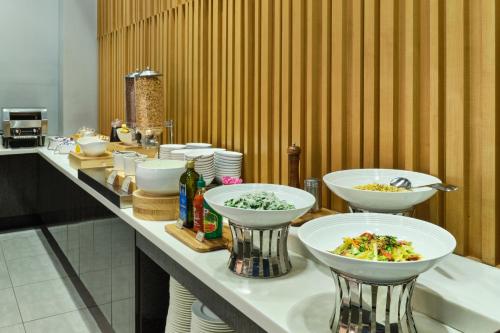 a buffet with bowls of food on a table at Hotel Atrium Jongno in Seoul