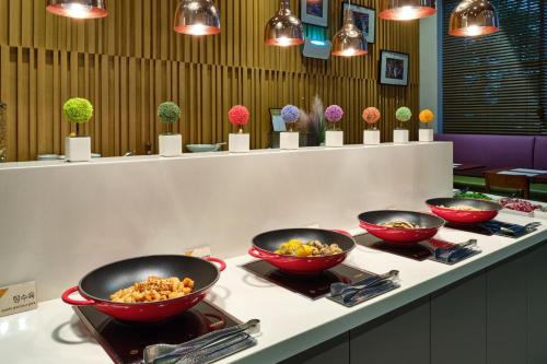 a buffet with three bowls of food on a counter at Hotel Atrium Jongno in Seoul