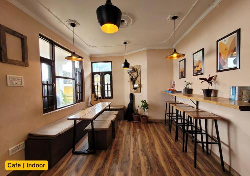 Young Monk Hostel & Cafe Dharamkot في ماكليود غانج: بار به كراسي ومكتب في الغرفة