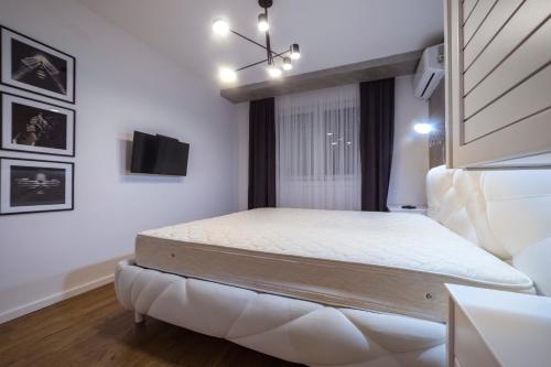 a bedroom with a bed and a tv on the wall at Apartman Pesic in Pirot