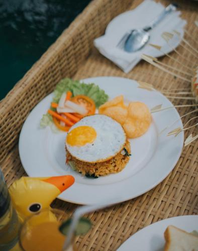 un piatto con un uovo e verdure su un tavolo di Alam Bidadari Seminyak a Seminyak