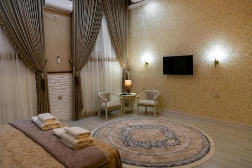 a bedroom with a bed with a tv and a table at Renaissance Boutique Hotel in Samarkand