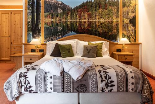 um quarto com uma cama com uma grande pintura na parede em Hotel Caminetto em Folgarida
