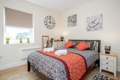- une chambre avec un lit doté d'oreillers orange et une fenêtre dans l'établissement Modern Elegant Luxury 1 bed flat Free parking, 