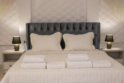 a large bed with white pillows and two lamps at Renaissance Boutique Hotel in Samarkand
