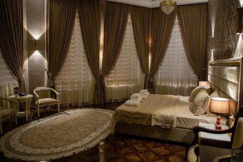 a bedroom with a bed with curtains and a chair at Renaissance Boutique Hotel in Samarkand