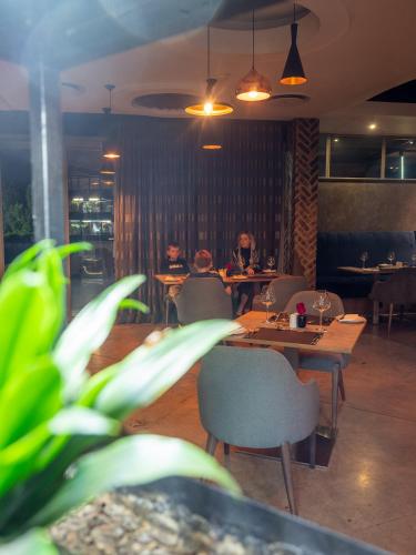 two people sitting at tables in a restaurant at Seven Villa Hotel & Spa in Johannesburg