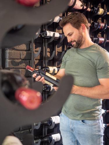 a man holding a gun in a rack of weapons at Seven Villa Hotel & Spa in Johannesburg