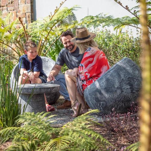 a man and a woman sitting on a bench with a child at Seven Villa Hotel & Spa in Johannesburg