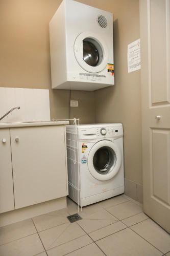a washing machine and a dryer in a kitchen at Centrepoint Apartments Griffith in Griffith