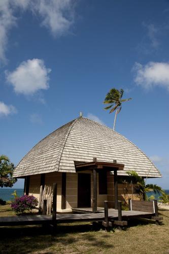 a small hut with a palm tree in the background at Hotel Tieti in Poindimié