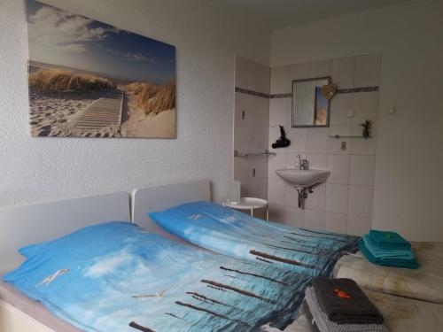 een slaapkamer met een bed en een wastafel bij Pension Küstenkind in Bentwisch