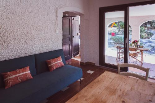 - un salon avec un canapé bleu et une table dans l'établissement Lilly - Lovely small Villa among Olive Trees, à Sarroch